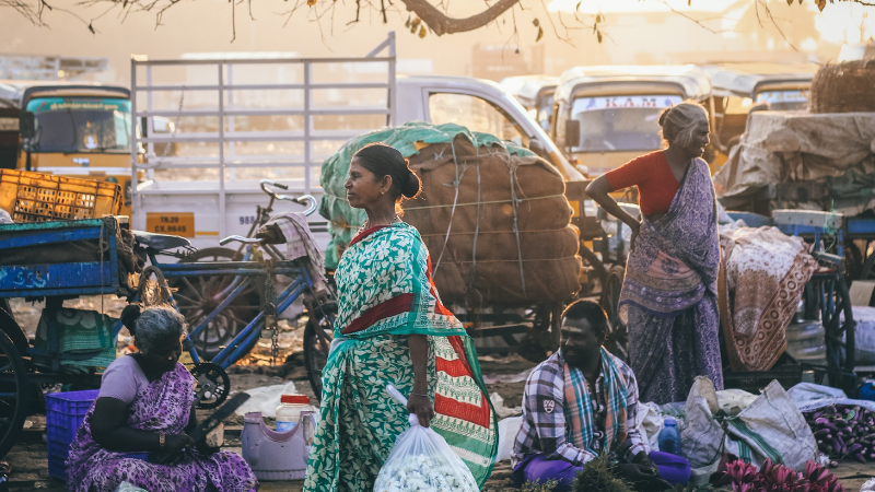 A woman walking through a street market in India